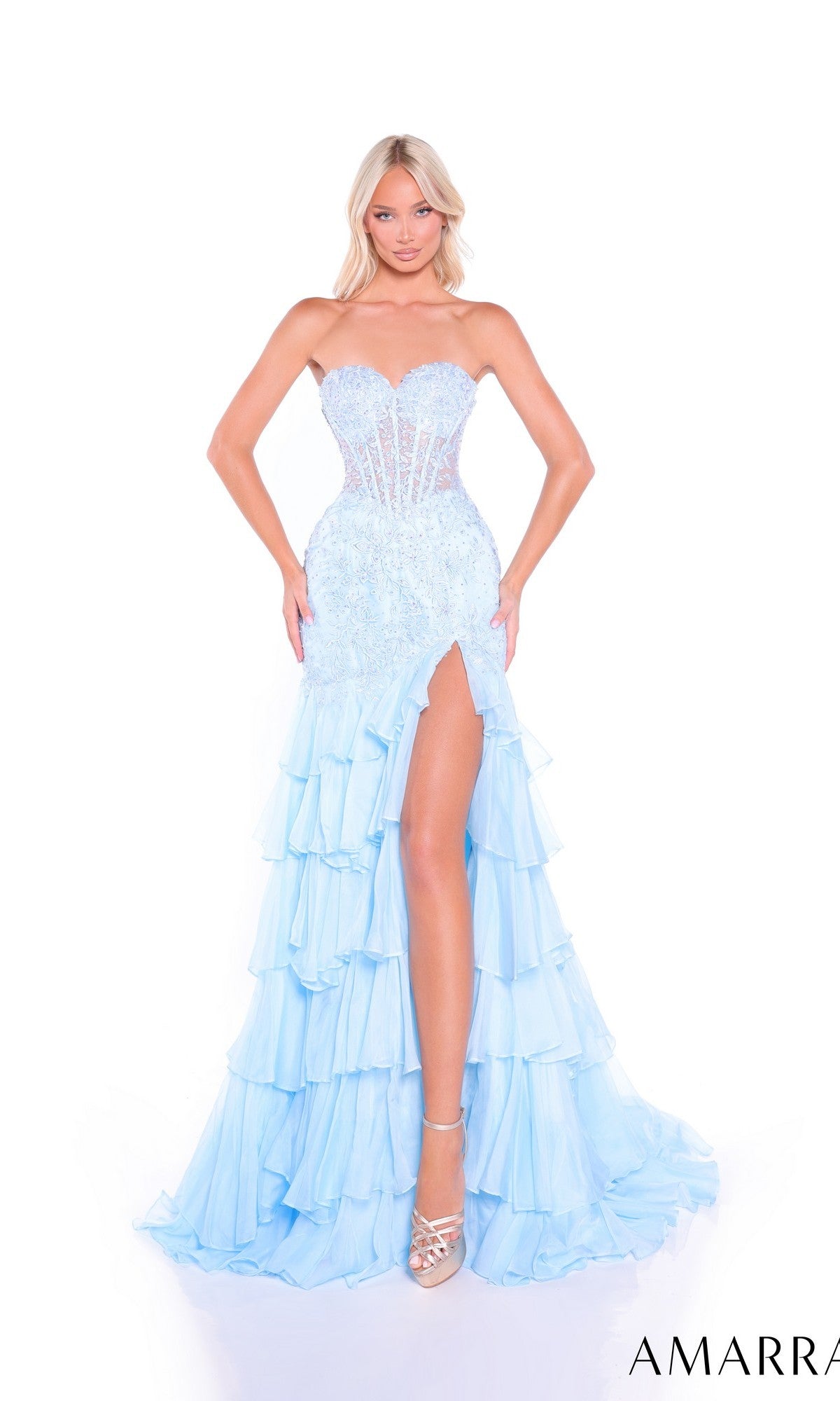 A woman poses against a white background in the Amarra 89467 long prom dress featuring a strapless light blue corset bodice, sequin accents, lace embroidery, high slit, and layered ruffle skirt.